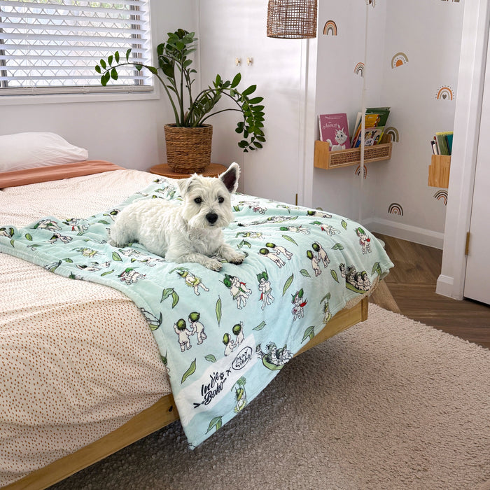 Cute white west highland terrier dog in kids room lying on May Gibbs gumnut babies dog and pet soft blanket