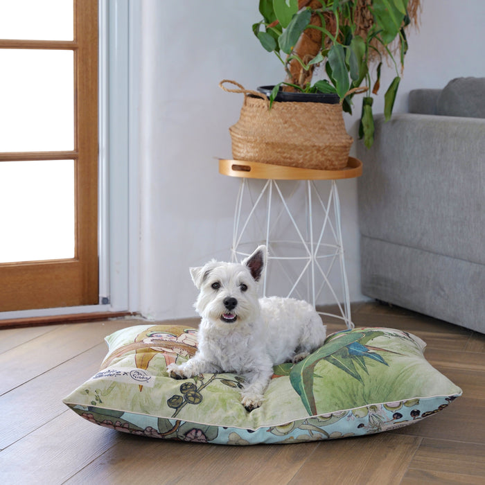 Happy westie terrier sitting on a large pet bed and dog bed cover in May Gibbs gumnut babies and bush babies design