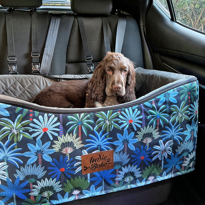 Dog lying down comfortably in a large dog car seat for safety