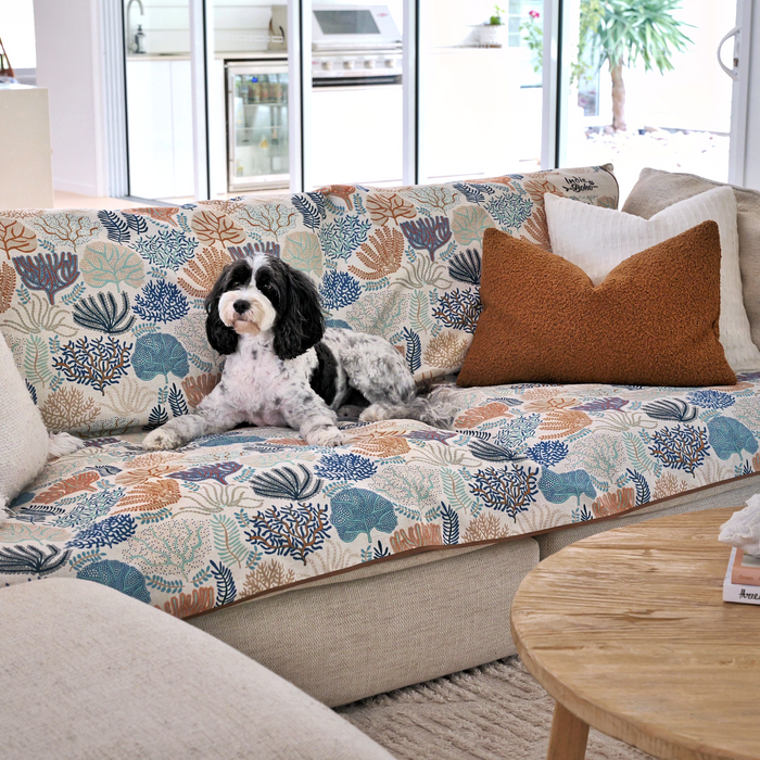 Dog sitting on a Coral Cove couch throw in a living room. Best couch protector Australia, designer prints, practical and beautiful