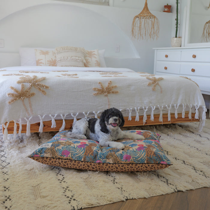 Cute cavoodle lying on a colourful dog bed pillow, with a fun leopard jungle design and leopard print dog bed. Leopard Luxe dog bed