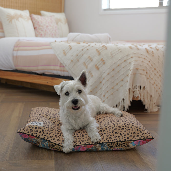 Cute Westie Terrier sitting on a luxurious dog bed with leopard print and a leopard jungle design, Australian designed dog bed